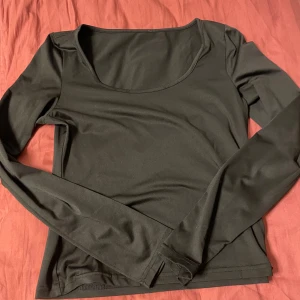 Svart långärmad topp med rund hals - Toppen har en slimad passform och är tillverkad i ett mjukt, stretchigt material som sitter skönt på kroppen.