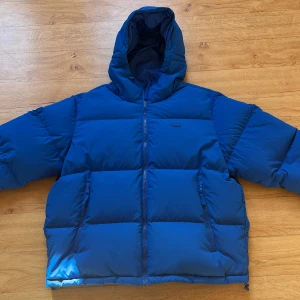 Pufferjacka från Lacoste - Säljer min blå Lacoste vinterjacka anledningen till försäljning är att den inte används längre. Den är äkta och använd endast en vinter. Har ett litet hål längst ner på ryggen (syns på bild) men påverkar inte funktionen eller användningen. Priset går att diskutera vid snabb köp