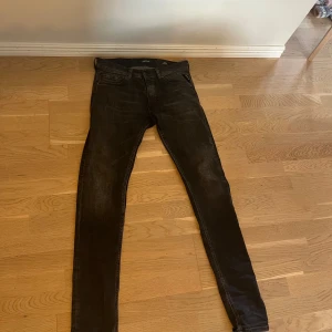 Svarta  jeans från Replay - Säljer ett par svarta  jeans från Replay med klassisk femficksdesign och snygga slitningar. Jeansen har låg midja och smal passform hela vägen ner. Perfekta för dig som gillar replay och vill ha ett par stilrena jeans i garderoben. Endas använda ett par gånger då de var lite små för mig i midjan. 