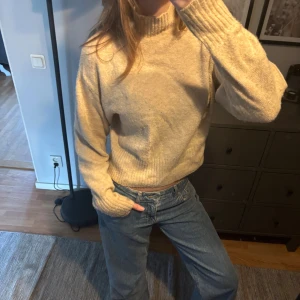 Beige stickad tröja - Säljer en beige stickad tröja med ribbad hals, ärmslut och nederkant. 