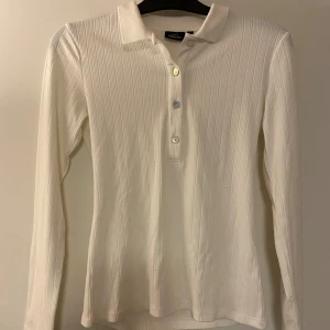 Vit ribbad cardigan/tröja - Säljer en stilren vit pikétröja från KappAhl med ribbad struktur och klassisk krage. Endast använt 1-2 gånger. Skriv om du har några frågor💕