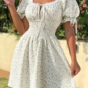 Vit blommig kortklänning med puffärm - Supersöt vit kortklänning från Shein med små gröna blommor, puffärmar med knyt och smockad midja. Klänningen är helt ny och är perfekt för sommarens alla tillfällen.