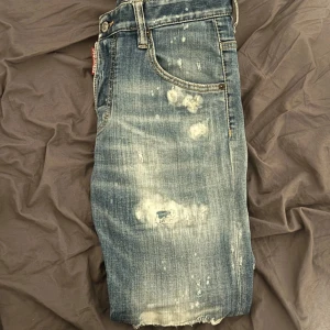 Blå jeans från Dsquared2 - Snygga blå jeans från Dsquared2 med slitna detaljer och en cool, tvättad look. De har en knappgylf och klassisk femficksdesign. Perfekta för en avslappnad stil med en touch av edge. . 