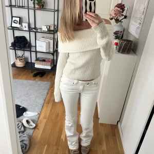 Offshoulder ribbad stickad topp H&M - Superfin offshoulder topp från H&M i ribbstickad, mjuk och krämvit kvalitet. Stickad med bred krage som går över axlarna och långa ärmar. Perfekt att styla med jeans eller kjol för en trendig look. Sällsn använd