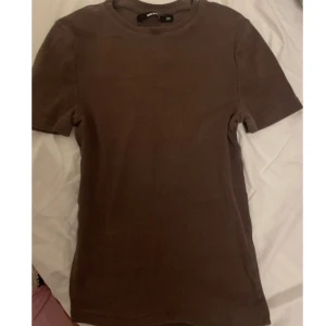 Tshrt - - Bra skick  - Mörkbrun - Längd: till under naveln - Ribbad - Strl Xs och passar även som S  Kontakta för mer info/ fler bilder