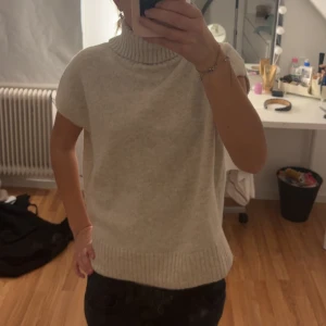 Beige stickad polotröja utan ärm - Jätte söt skickad polotröja som tyvärr inte kommer till användning längre den är i jätte bra skick inga slitningar eller hål 
