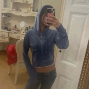 Blå croppad hoodie med huva - Säljer en blå croppad hoodie med huva och snörning. Tröjan har långa ärmar och en avslappnad passform, perfekt för en chill och trendig look. Materialet känns mjukt och skönt mot huden.