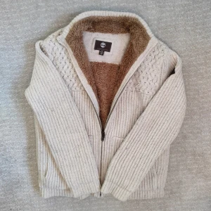 Päls fodrad Timberland cardigan  - Säljer en stickad cardigan med pälsfodring från märket Timberland. Väldigt tjock och varm, med en elegant, stilren och komfortabel design. Tveka inte att höra av dig vid minsta fundering!