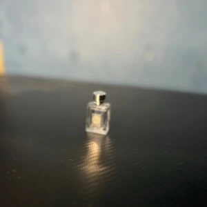 Versace miniparfym med silverdetaljer - Snygg miniflaska från Versace med klassisk Medusa-logga och silverfärgat lock. Perfekt storlek att ta med i väskan eller ge bort som present. Volym och ingredienser syns ej på bilderna.