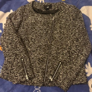 Svartvit cardigan jacka från H&M - Säljer en svartvit cardigan jacka från H&M i storlek 42. Jackan har grovstickad struktur, sned dragkedja framtill och dragkedjor vid ärmsluten. Perfekt för dig som gillar en stilren men ändå chill look.