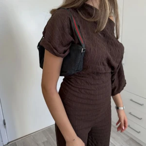 Vintage Gucci väska  - Äkta vintage boat axelväska från Gucci i tyg med klassiskt GG-mönster över hela väskan. Axelremmen är i grönt och rött med en sportig känsla o är lite slitet på undersidan men syns knappt. Väskan har dragkedja upptill och metallplatta med Gucci-logga framtill. Perfekt storlek för det viktigaste. Kommer med äkthetsbevis från The Vintage Bar. Priset kan diskuteras. Vid köp av två eller fler varor får du dessutom välja en present 🎁❤️ (presenterna kan jag visa i DM eftersom de inte finns upplagda hä