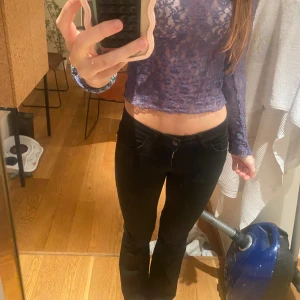 Svarta bootcut jeans med låg midja - Säljer ett par svarta jeans med bootcut och låg midja. Jeasnen är från Nelly och är ganska nya. Innerbenslängden är ca 80cm och midjemåttet är cirka 30cm💖