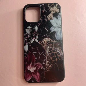 iPhone Skal Leopard & Blommor - Stilrent skal till iPhone 12 mini med leopard- och blomsterdesign samt gulddetalj. Skalet är i mycket gott skick utan synligt slitage. Ger bra skydd och unik look till din mobil. 