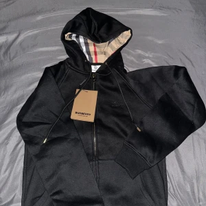 Svart Burberry hoodie med dragkedja - Helt ny oanvänt burberry zip up med mönster inuti, storlek S. pris kan diskuteras, men kommer inte gå lågt.