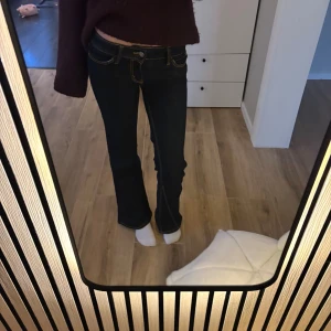 Bootcut jeans från Cheap Monday - Mörkblå bootcut jeans från Cheap Monday med kontrasterande gula sömmar. Klassisk femficksmodell med låg midja och snygg passform. Jeansen är tillverkade i denim och har en stilren look som passar till många olika outfits. Lite korta i längden för mig som är 170 cm lång. 