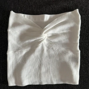 Vit ribbad bandeau tubtopp - Säljer en vit bandeau tubtopp med twistad detalj framtill. Oanvänd 🤍
