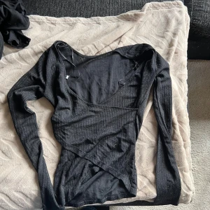 Svart glittrig topp - Svart långärmad glitter topp från Gina Tricot i storlek XS. Toppen har glittriga detaljer i tyget och har v-ringning 