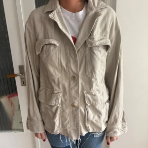 Beige utilityjacka från Zara XS - Säljer en beige utilityjacka från Zara i bomull. Jackan har fyra stora fickor framtill, knäppning med knappar och avslappnad passform. Perfekt för lager-på-lager och har en cool, lite oversized vibe. Använd 1 gång. 