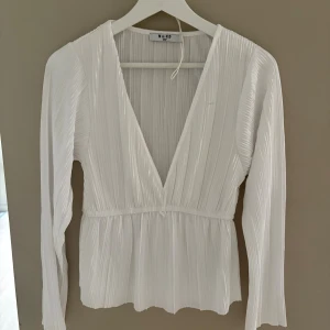 Söt vit blus - En vit blus i storlek S från Na-Kd, supersöt och jättebra i skick! Skönt material med v ringning där fram