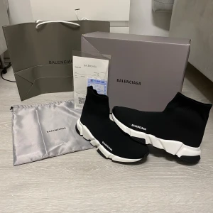 Balenciaga skor - Svarta Balenciaga Speed Trainer sneakers med vit chunky sula och stickad ovandel i syntetmaterial. Strumpliknande passform och logga på sidan. Supersnygga och trendiga skor som ger en sportig vibe till din outfit.