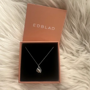 Silverhalsband från Edblad - Säljer ett silverhalsband från Edbland med en tunn kedja och ett droppformat hänge. Fick det i studentpresent men har aldrig använt det, så det är i nyskick. Är utlagd på fler ställen, nypris 400 kr