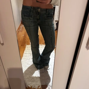 Bootcut jeans från Nelly, mörkblå - Mörkblå bootcut jeans från Nelly med låg midja. Snygga detaljer med framfickor och markerade sömmar längs benen. Klassisk femficksmodell i stretchigt jeanstyg som sitter skönt och ger en schysst siluett.