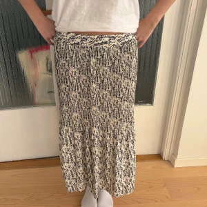 Mönstrad långkjol från Primark - Säljer en snygg långkjol från Primark i storlek 34. Kjolen har ett svartvitt abstrakt mönster och är gjord i mjuk bomull. Den har en skön, normal passform och resår i midjan för extra komfort. Perfekt för dig som gillar coola mönster och avslappnad stil.