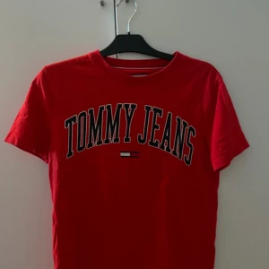 Tommy Jeans röd t-shirt + grå t-shirt - Snygg röd t-shirt från Tommy Jeans (storlek S) med stort tryck över bröstet i svart och vitt. Skickar även med den gråa tröjan som är i M bara för att! ☺️