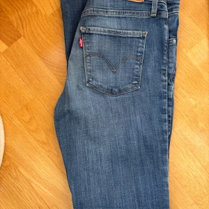 Levi's 315 shaping bootcut jeans W26 L32 - Snygga blå Levi's jeans i bootcut-modell med klassiska fem fickor och tydliga sömmar. Färg: Blue denim 