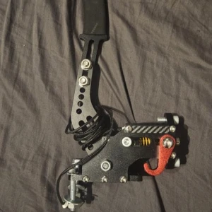 USB Handbroms för PC Racing Simulator - Robust USB-handbroms för PC racing simulatorer. Metallkonstruktion med justerbar fjäder, ergonomiskt handtag och USB-anslutning. Passar perfekt för drifting och rallyspel. I gott skick utan synligt slitage eller defekter.