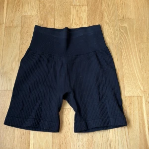 Svarta ribbade shorts SOC XS/S - Svarta cykelshorts från SOC i ribbat material med hög midja och tight passform. Dessa har varit ett par favoriter men säljer pga att jag inte använder dom längre!