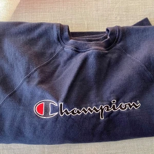 Mörkblå Champion sweatshirt L - Säljer en mörkblå sweatshirt från Champion i storlek L. Tröjan har klassisk rund hals, broderad logga framtill och är tillverkad i mjuk bomullsmix. Oversized. Perfekt för en chill och sportig stil. Bredd över rygg 57 cm. 