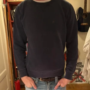 Mörkblå sweatshirt från Replay, S - En stilren mörkblå sweatshirt från Replay i bomull. Tröjan har rund halsringning, ribbade muddar och en liten broderad R-logga på bröstet. Perfekt för dig som gillar en clean och enkel look.