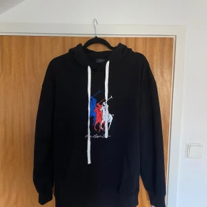 Svart hoodie Polo Ralph Lauren M - Sprillans ny hoodie från polo Ralph lauren. Säljer då den är lite för liten för mig. Storlek M men passar också till mindre L. Hoodien är i lite tunnare material. Vid övriga frågor tveka inte att höra av.
