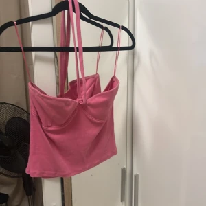 Rosa -topp  - Säljer en snygg rosa-topp med. Toppen är croppad och har en stilren design som passar perfekt till jeans eller kjol. Materialet känns mjukt och bekvämt mot huden. Perfekt för dig som vill ha en trendig och färgstark look.