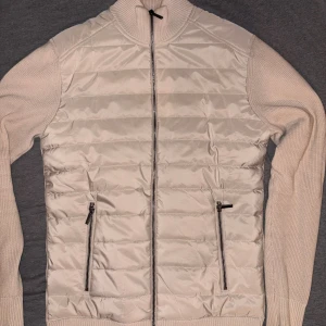 Beige stickad cardigan jacka Small - Snygg beige cardigan jacka med quiltad framsida och stickade ärmar. Inget populärt märke i Sverige, den är köpt i Australien. Den kostade mig ca 1500 så vill gärna ha några hundra iallafall. Jackan är i XS men det blir Small i Sverige, dem har andra storlekar i Australien.