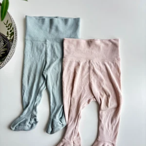 Två byxor med fot - Två par byxor med fot i pastellfärger, ett par ljusblå och ett par ljusrosa. 