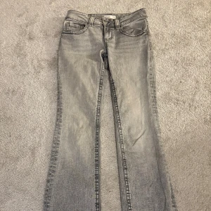 Grå bootcut jeans från Perfect Jeans - Snygga grå jeans från Ginatricot i bootcut-modell. Jeansen har klassisk femficksdesign, lite lågare midja och raka ben som blir vidare nertill. Tillverkade i ett mjukt denimtyg som sitter skönt på kroppen. Perfekta för dig som gillar en avslappnad men trendig look. 