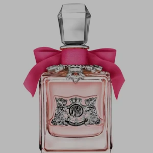Juicy Couture parfym med rosa rosett - Snygg parfym från Juicy Couture med en rosa rosett – perfekt för dig som vill sticka ut och addera en touch av glamour till din stil. Ikonisk design som passar dig som gillar trendiga accessoarer.