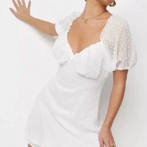 Vit kort prickig klänning Missguided - Superfin vit kort klänning från Missguided med puffärmar och v-ringning. Klänningen har ett diskret prickigt mönster i tyget och dragkedja bak. Lätt och luftig modell, perfekt till student endast testad eftersom den var för stor på mig stolek 38! Om fler bilder önskas är de bara att fråga!💕