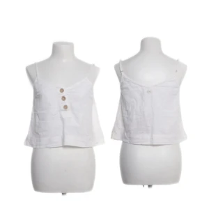 Vit linnetopp från Rip Curl XS - Säljer en vit linnetopp från Rip Curl i storlek XS. Toppen har smala axelband, croppad passform och tre snygga träknappar framtill. Tillverkad i luftigt linne, perfekt för varma dagar. Enkel och stilren design som är lätt att matcha.