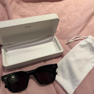 Svarta solglasögon CHIMI modell 04 - Snygga svarta solglasögon från CHIMI, modell 04, med markerad fyrkantig båge och mörka glas. Kommer med original vit hård ask och tygpåse. Designade i Stockholm och perfekta för en clean och modern look.