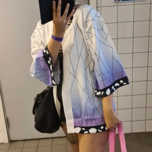 Demon slayer kimono - Köpt på Comic Con Stockholm, en demon slayer kimono. Använd 2 gånger enbart. Skönt material som inte är tungt. Jag är storlek S vanligtvis och den känns inte som man drunknar i den fast den är en större storlek