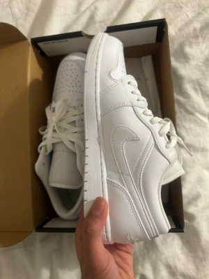 Nike Air Jordan 1 Low Triple White - Nike Air Jordan 1 Low i helvitt skinn med klassisk swoosh på sidan och perforerad tåbox. Lågt skaft, vita skosnören och diskret Jumpman-logga på plösen. Snygg och clean siluett som passar till allt. Kommer i originalkartong. Aldrig använda 