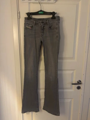 Grå bootcut jeans från Diesel - Fina gråa jeans från diesel som tyvärr blivit för små. mellan lowwaist och midwaist. enda defekten syns på bild 2