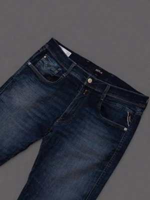 Replay Anbass mörkblå jeans - Snygga Replay Anbass jeans i mörkblå tvätt med klassisk femficksdesign och guldfärgade detaljer vid fickorna. Jeansen har en slim passform och är tillverkade i stretchig denim för extra komfort. Perfekta för dig som gillar en modern och stilren look. Storlek W36, L34