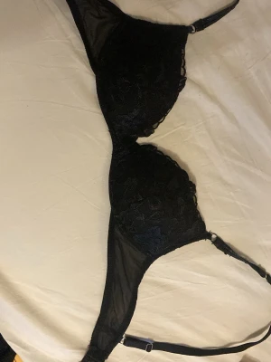 Intimissimi bh gioia  - Säljer en svart bh med tunna axelband och spetsdetaljer. Bhn har blommigt spetsmönster och meshpartier på sidorna. Justerbara band för perfekt passform. Perfekt för dig som gillar en stilren och elegant look. Hyfsat bra skick, storlek 75b