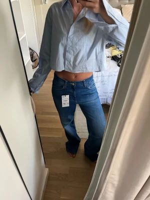Blå baggy jeans med rak passform - Säljer ett par blå jeans från Zara med medelhög midja och rak, baggy passform. Jeansen har klassisk femficksdesign och är tillverkade i jeansmaterial. Perfekta för en avslappnad och trendig look.