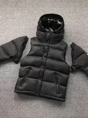 Burberry jacka - Säljer en svart dunjacka från Burberry med avtagbara ärmar och stor huva. Västen har två dragkedjeförsedda fickor framtill och klassiskt rutigt foder i huvan. Stängs med både dragkedja och knappar. Perfekt för lager-på-lager och riktigt snygg streetstil.