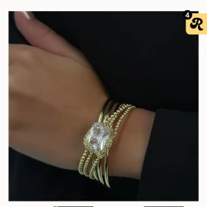 Icon edit cuff armband - guldigt armband med stor klar sten från Ioaku, helt ny. Og pris 800kr